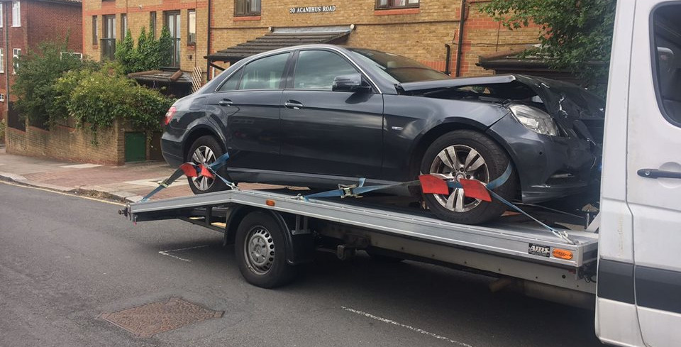 Recovered car being safely transported on a tow truck in London