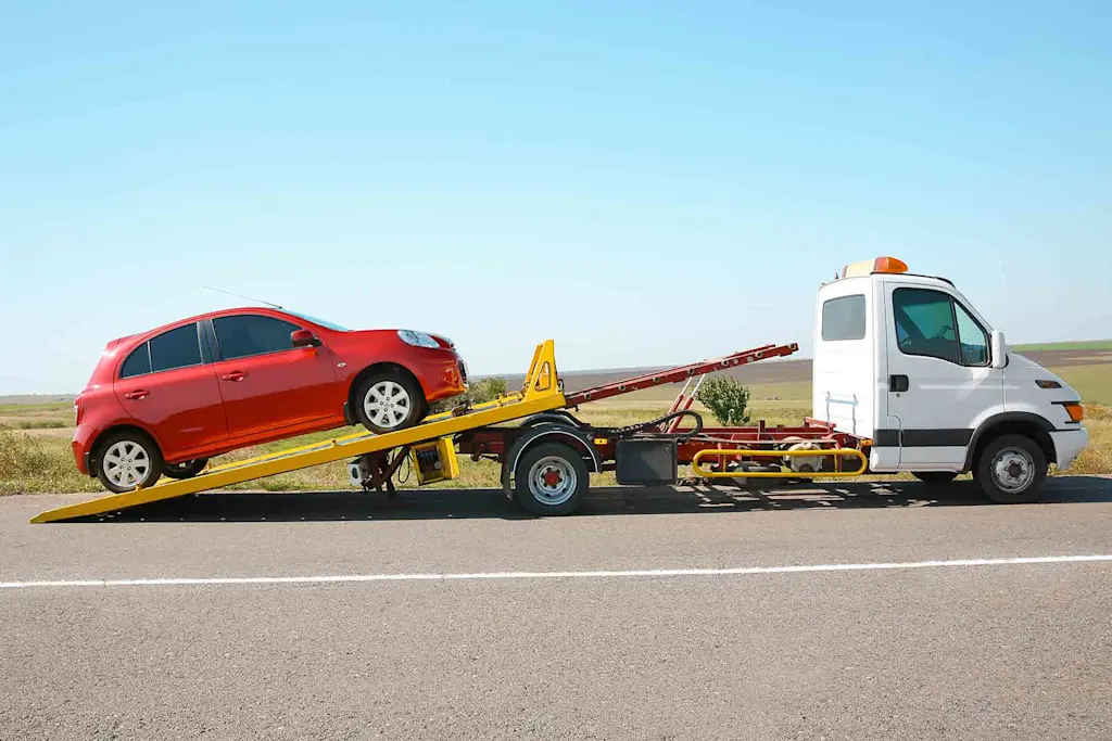 Recovery driver securing a broken down car on a tow truck in London